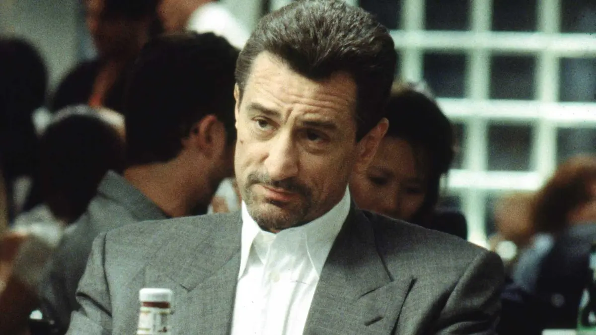 Robert de Niro sits at a dinner table across from Al Pacino in Michael Mann's Heat