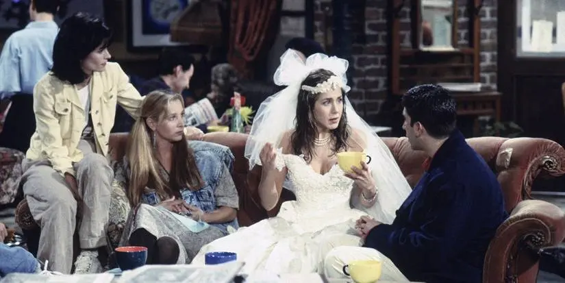 Rachel in her wedding dress talking to Phoebe, Ross, and Monica at Central Perk in Friends.