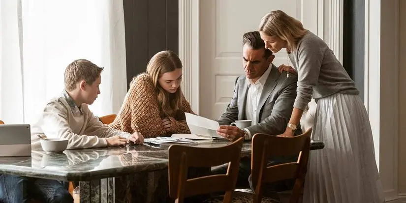 The Brannock family examining mail at the table in The Watcher