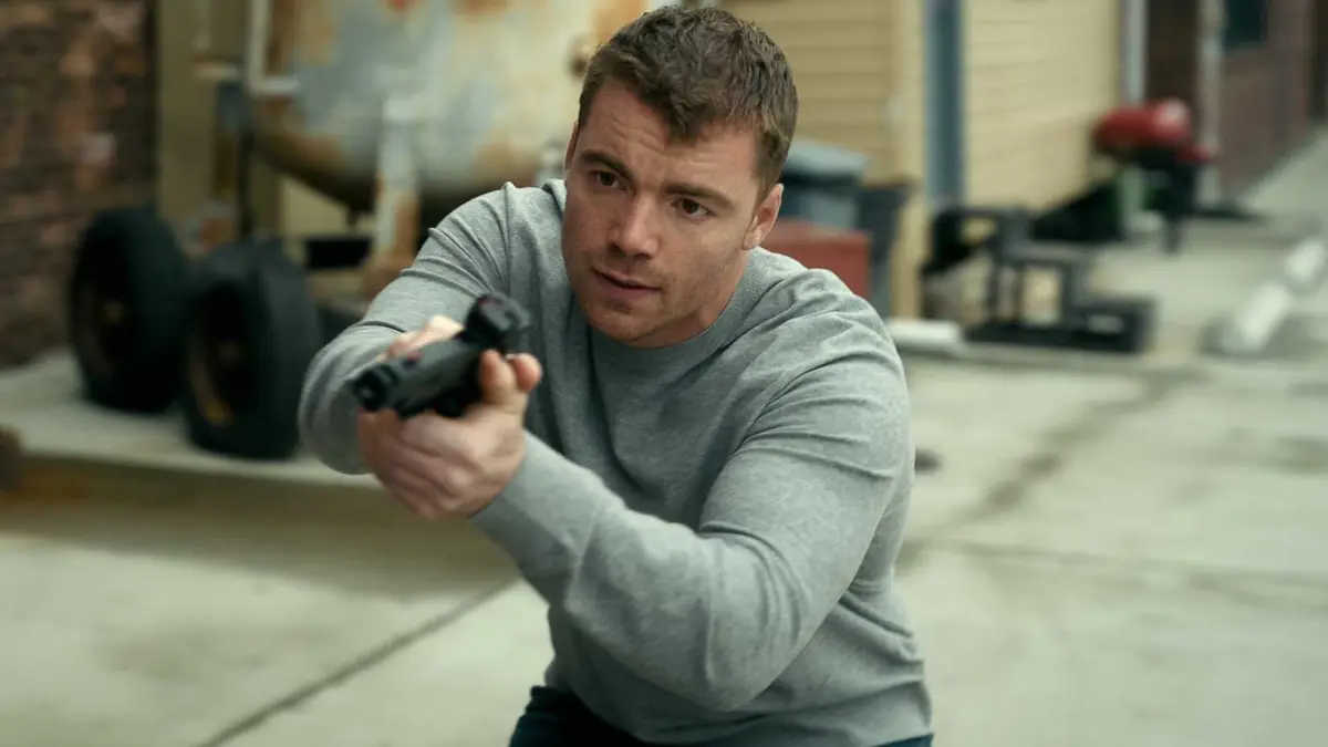 Gabriel Basso as Peter Sutherland pointing a gun in episode 309 of The Night Agent (1)