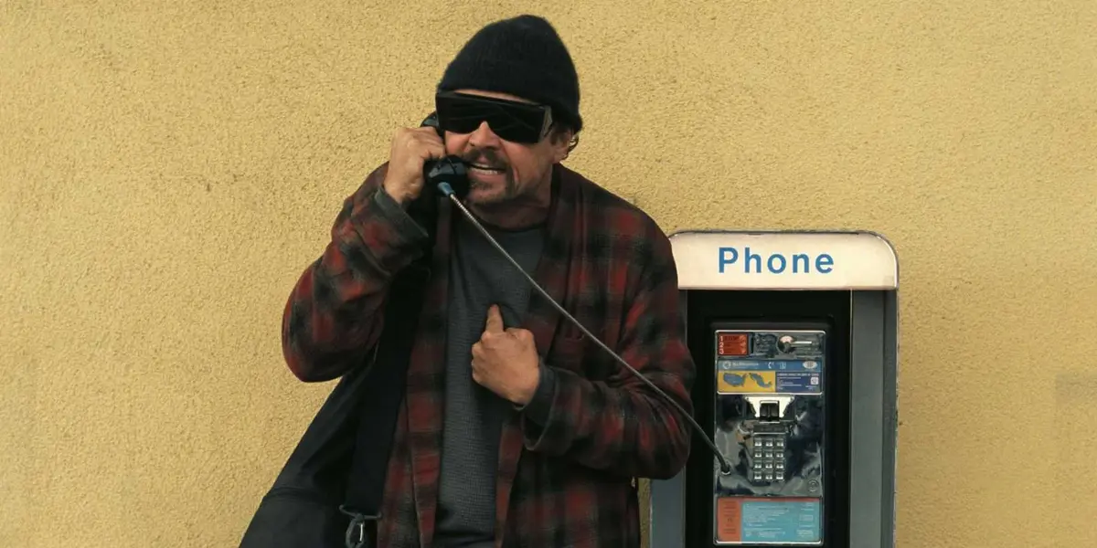 Bob wearing sunglasses at a payphone.