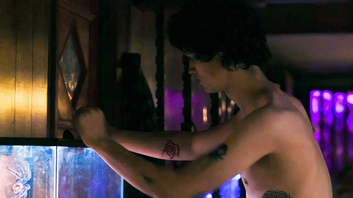Arthur Conti as Billy Nolan standing shirtless in front of his snake tank in Carrie