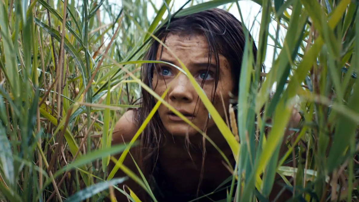 Nova hides in the grass in Kingdom of the Planet of the Apes