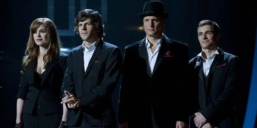 The Four Horsemen in black suits on stage in Now You See Me.
