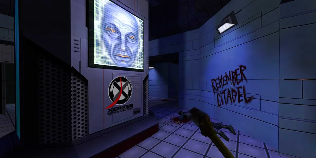 A screenshot showing the desolate hallways of System Shock 2, a screen showing an AI face on one wall, graffiti on the other and a dead body.