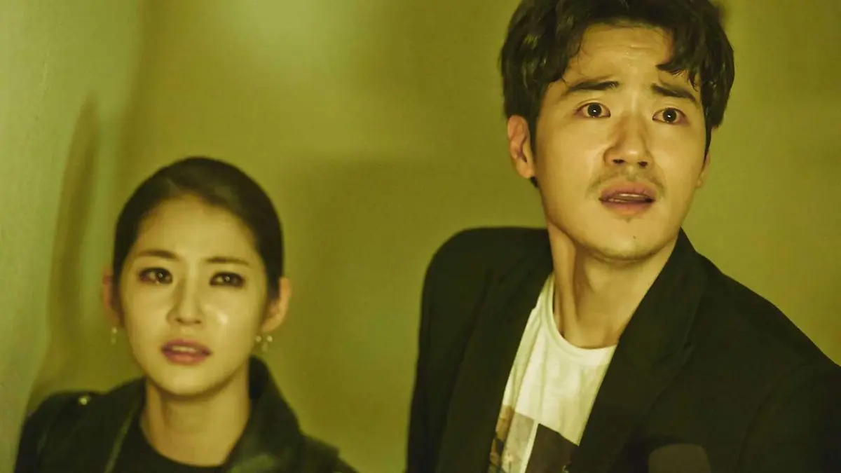 A Korean man and woman are staring at something, both look like they've been crying