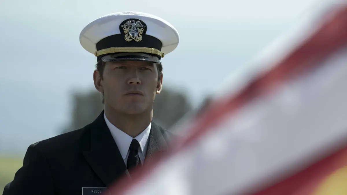 Chris Pratt as James Reece looking at an American flag in the foreground in The Terminal List season 1