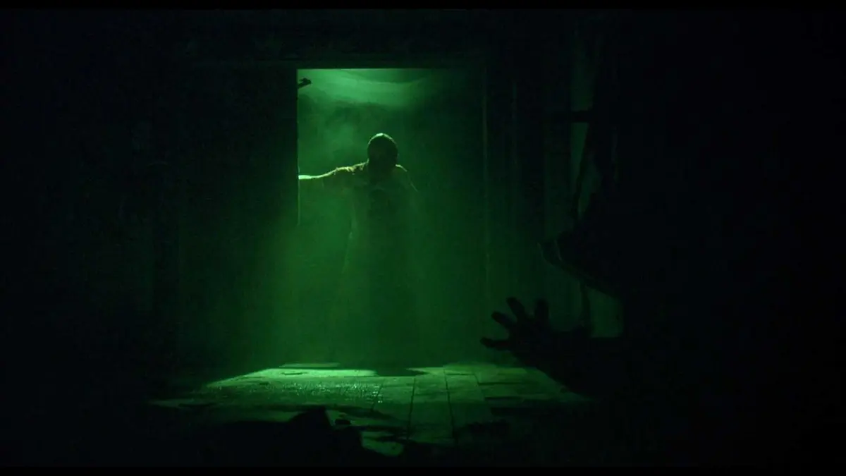 Jigsaw saying "Game Over" and slamming a door as Adam raches out in Saw (2004)