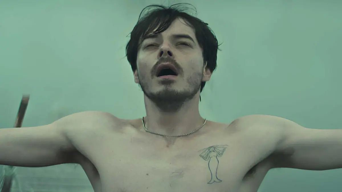Charlie Heaton‘s Wade standing with his arms wide open in Netflix’s Below
