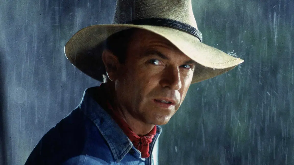 Sam Neill stands in the rain as Dr Alan Grant from Jurassic Park