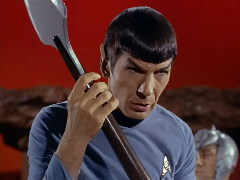 Mister Spock looks menacing and entranced as he hefts a heavy blade in Star Trek: The Original Series.