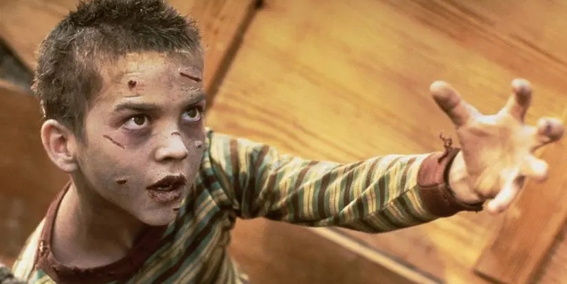 A little boy looks like a zombie and raises his hand for someone in AMERICAN GOTHIC