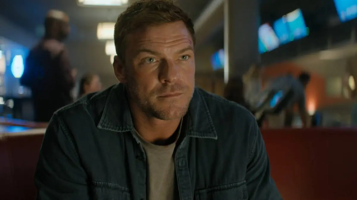 Alan Ritchson as Reacher in a bowling alley.