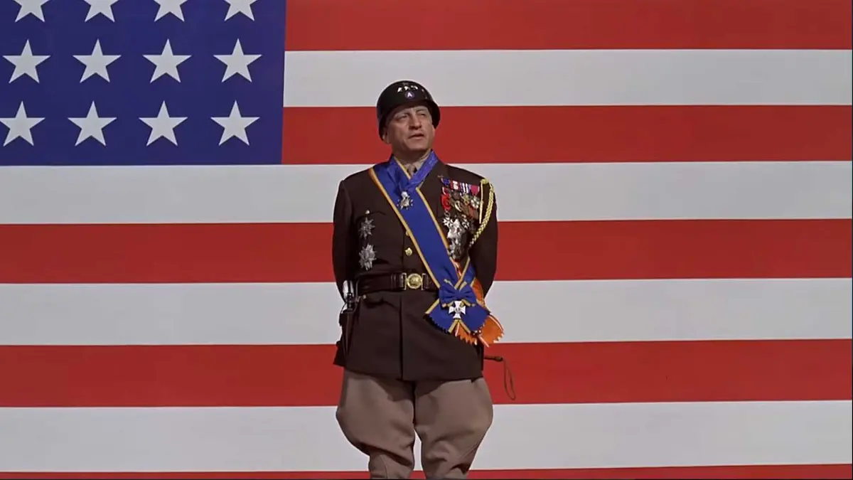 A general giving a speech in front of an American flag in Patton (1970)