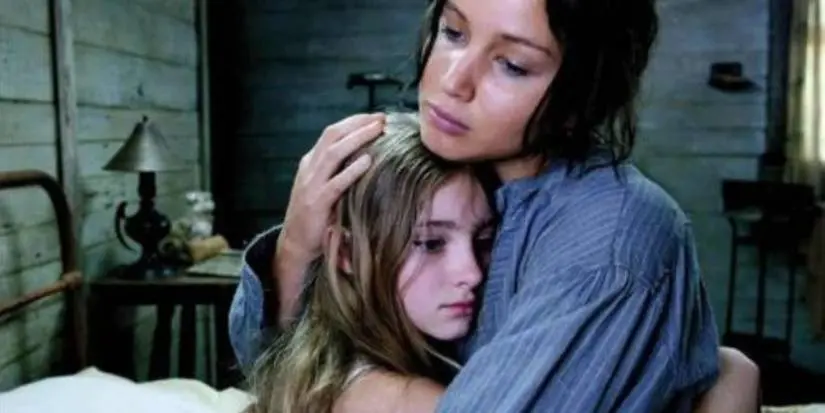 Katniss holds Prim in the opening scene of The Hunger Games.