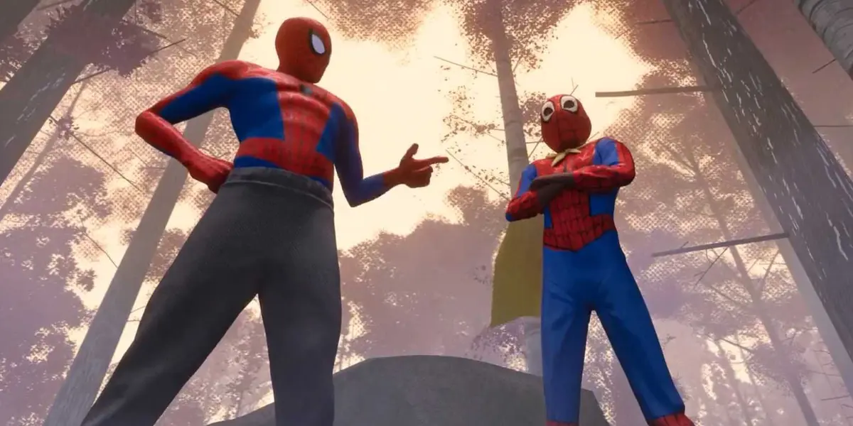 Peter B. Parker stands next to Miles Morales and points at him wearing a cape in Spider-Man Into the Spider-Verse.