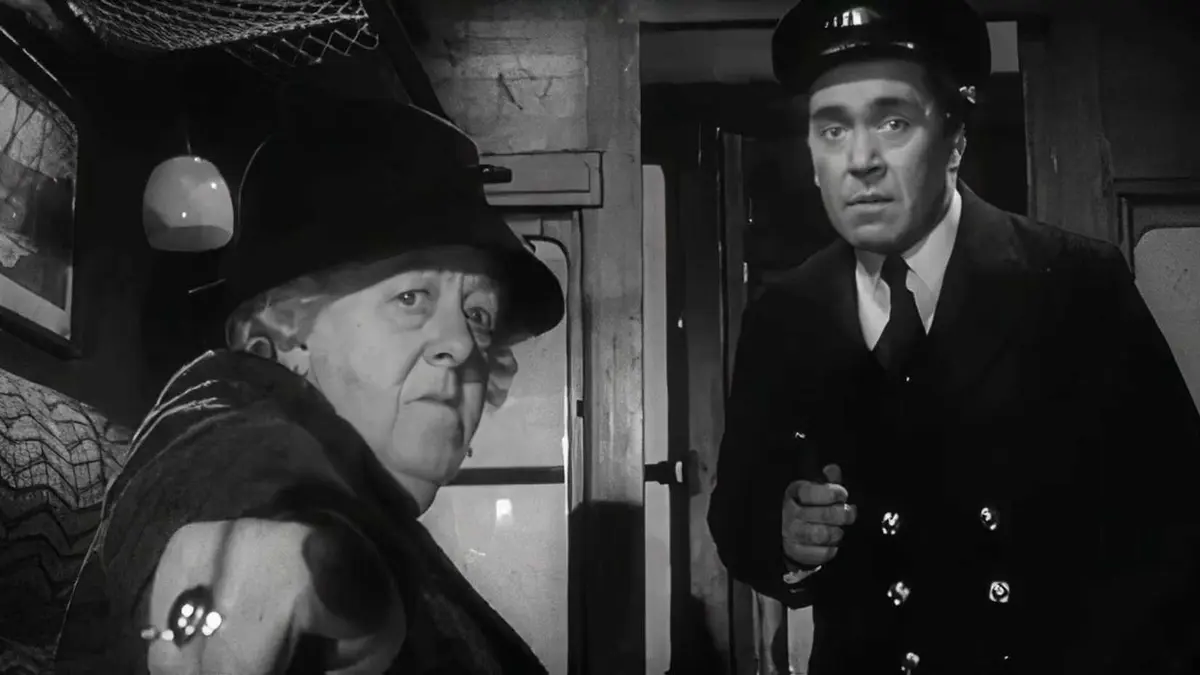 Miss Marple pointing at something off-screen to a Train Conductor while riding a train in Murder She Said