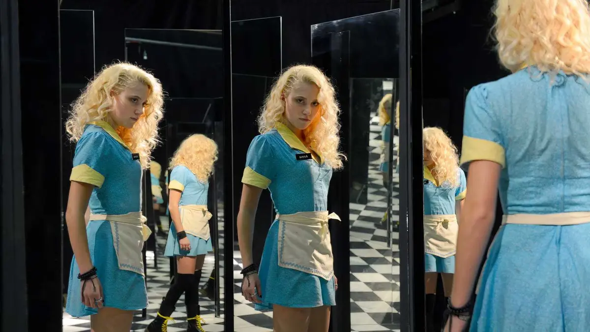 Maika Monroe as Anna looking in a hall of mirrors in The Guest (2014)
